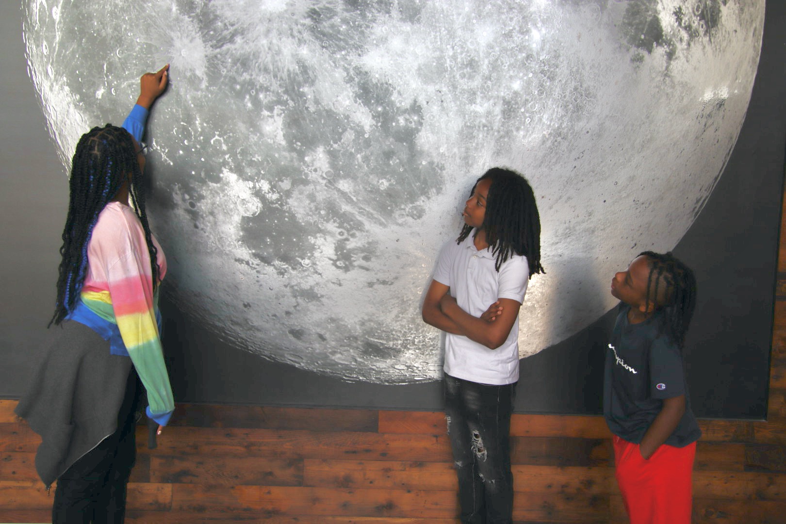 children in front of moon photo at Moonshot Museum